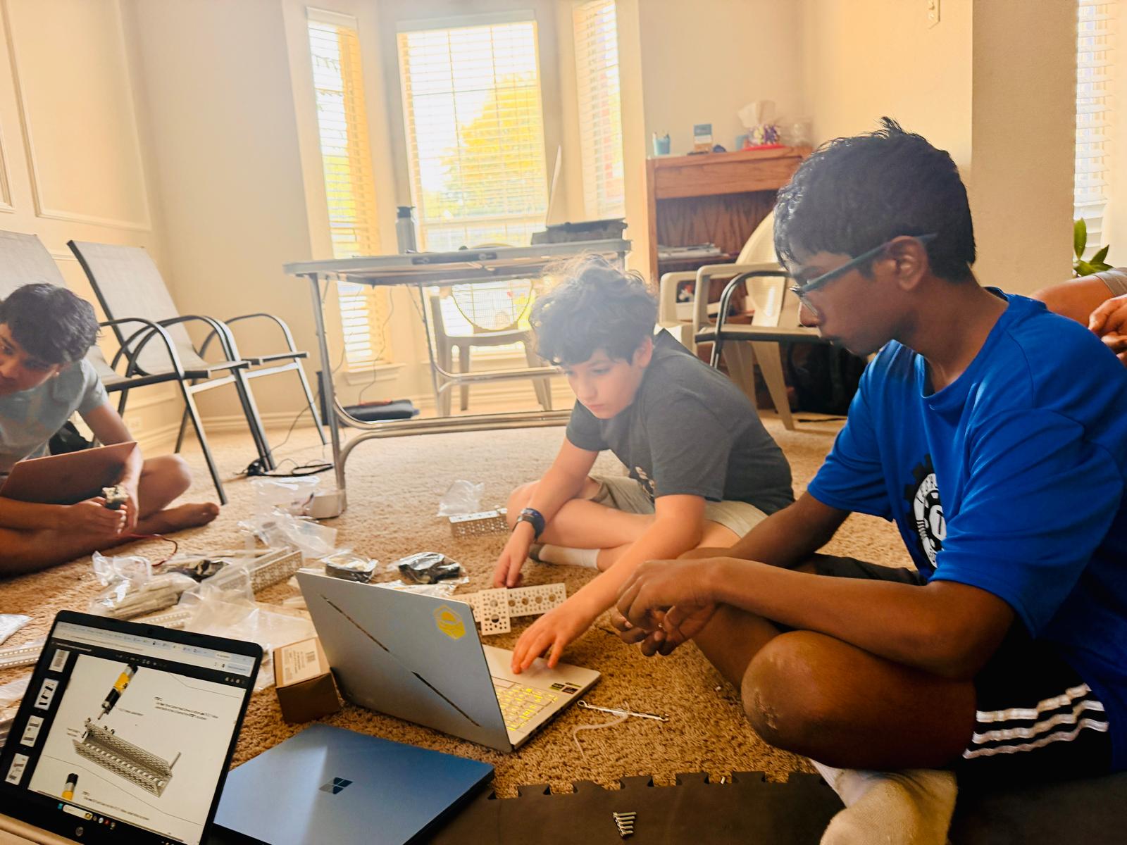 A mentor and team members learning together during a robot build session